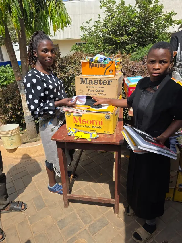 Girls receiving new exercise books