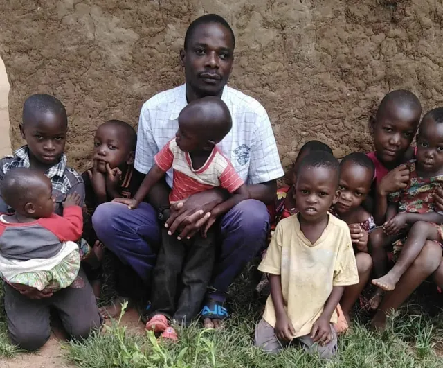 Founder Suleiman Ndikumana Nkanda sitting with young children
