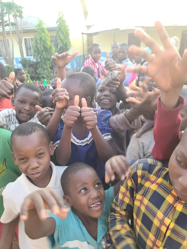 Smiling children at New Hope giving a thumbs up
