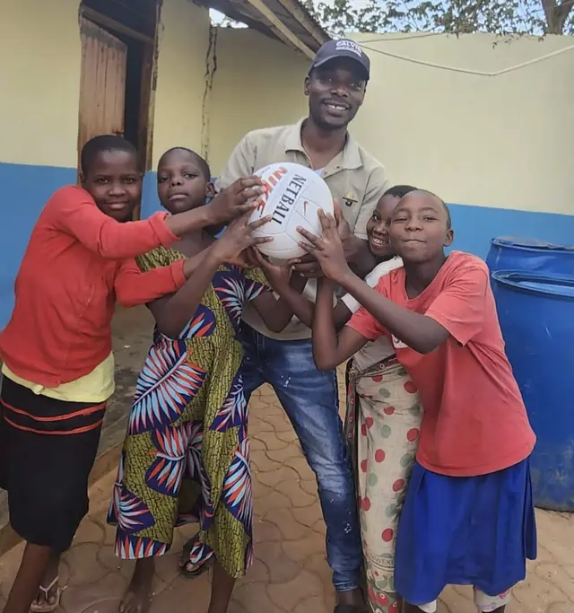 Girls with a new netball and a caretaker